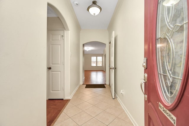 hallway featuring light tile patterned floors and ornamental molding