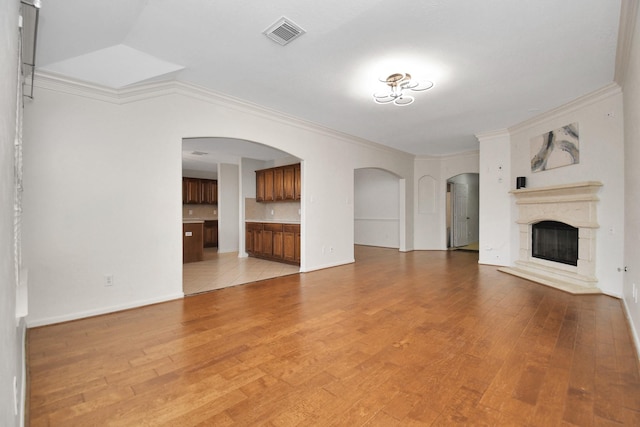 unfurnished living room with light hardwood / wood-style floors and ornamental molding