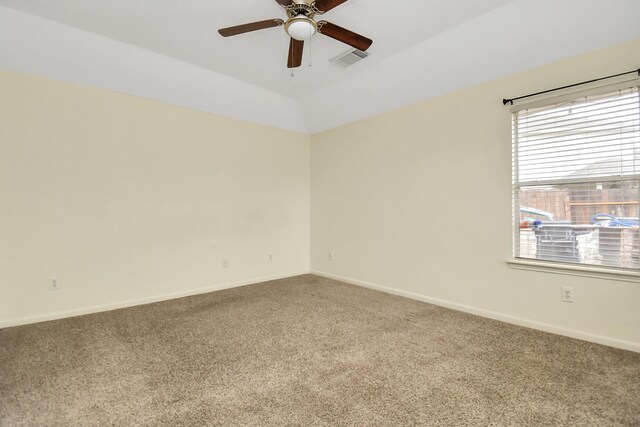 carpeted spare room featuring a tray ceiling, ceiling fan, and lofted ceiling