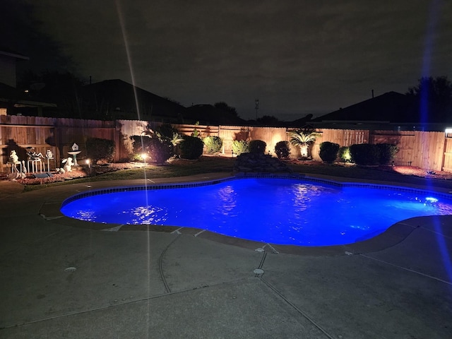 view of pool at twilight