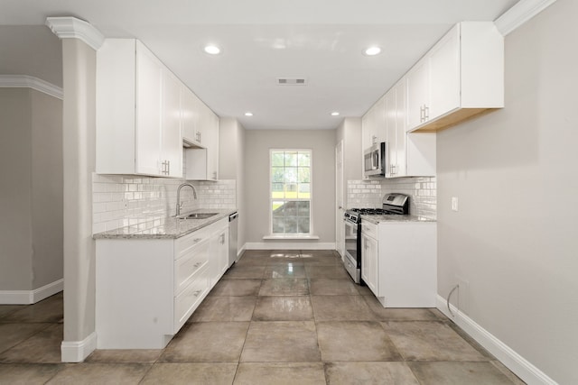 kitchen featuring white cabinetry, sink, appliances with stainless steel finishes, and ornamental molding