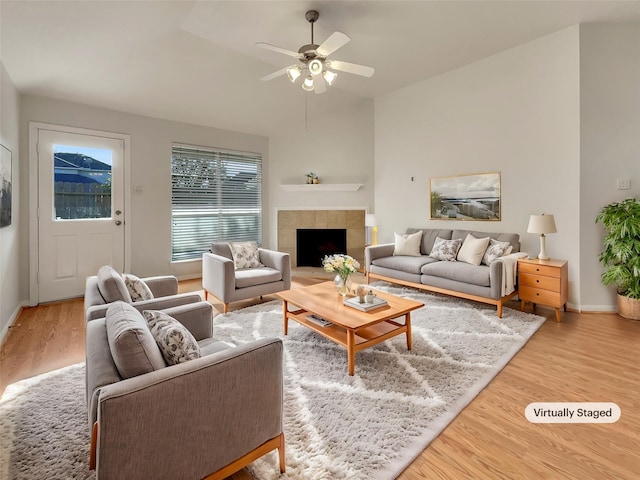 living room featuring hardwood / wood-style flooring, ceiling fan, and a fireplace