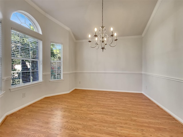 empty room with a wealth of natural light, hardwood / wood-style floors, and crown molding