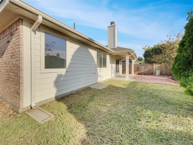 rear view of property featuring a yard and a patio area