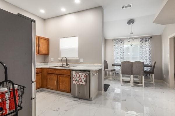 kitchen with hanging light fixtures, sink, and appliances with stainless steel finishes