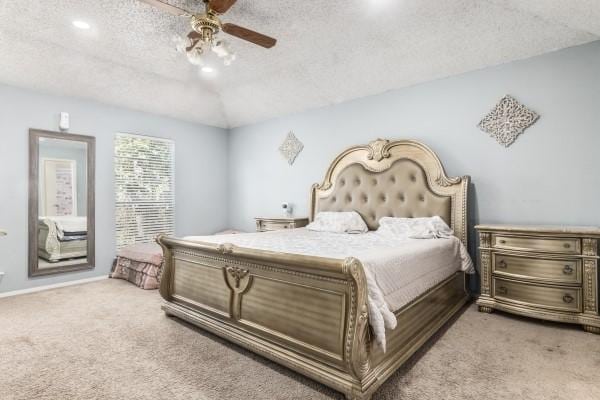 bedroom featuring a textured ceiling, light colored carpet, and ceiling fan