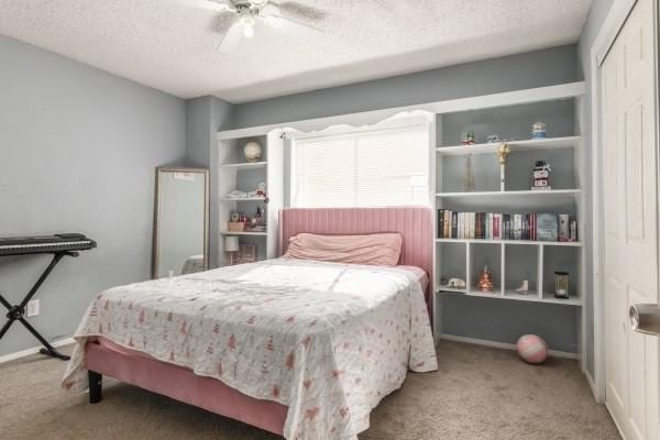 bedroom featuring carpet flooring, ceiling fan, a closet, and a textured ceiling