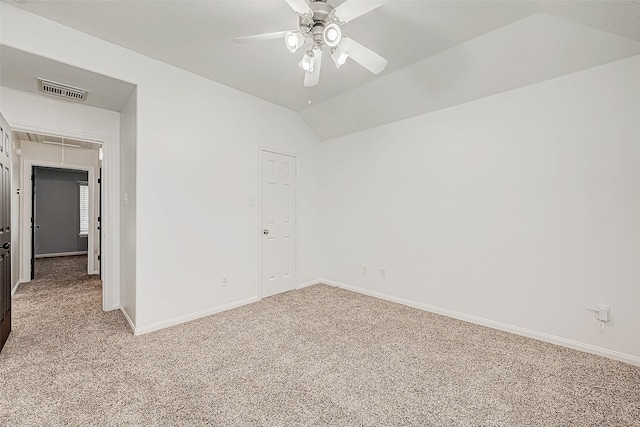 spare room featuring light carpet, ceiling fan, and vaulted ceiling