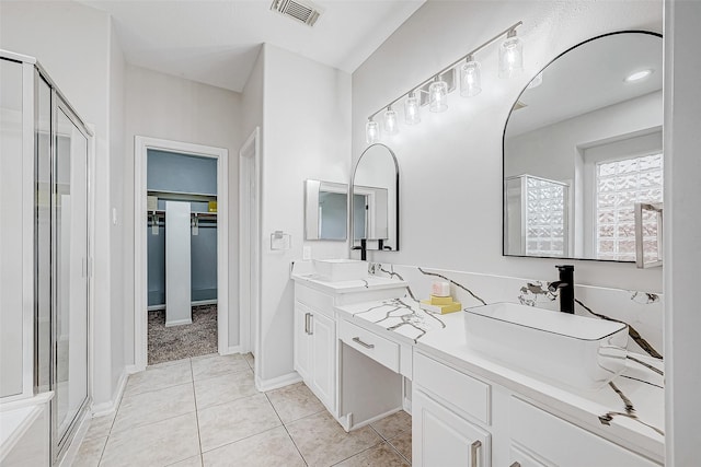 bathroom featuring tile patterned floors, vanity, and a shower with shower door