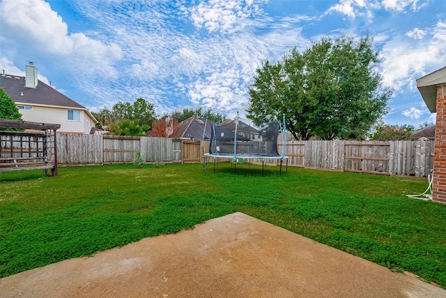 view of yard featuring a trampoline and a patio