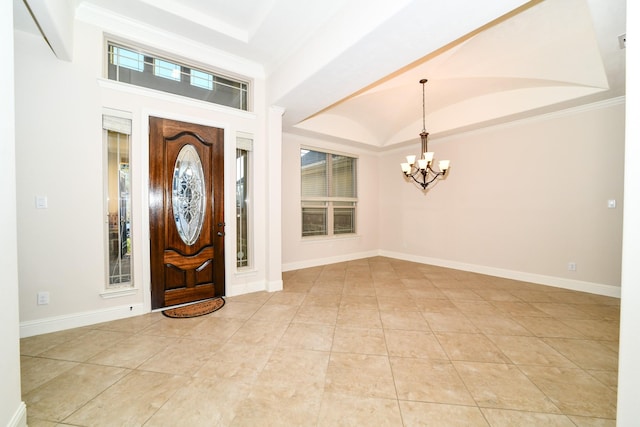 foyer with a chandelier, a healthy amount of sunlight, and crown molding