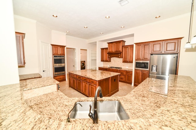 kitchen featuring sink, light stone counters, crown molding, a center island with sink, and appliances with stainless steel finishes