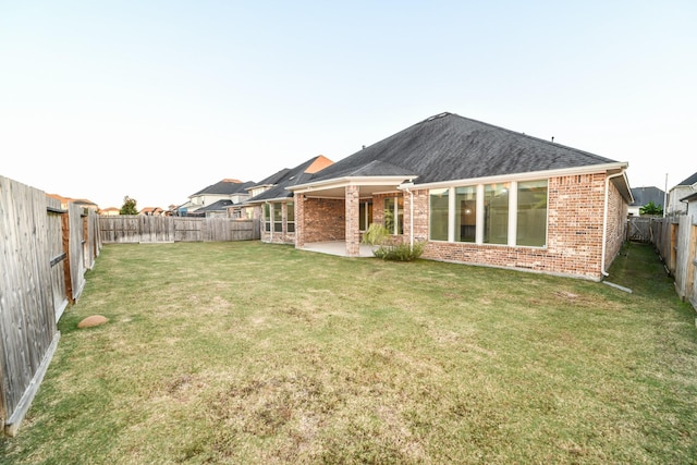 rear view of house with a yard and a patio