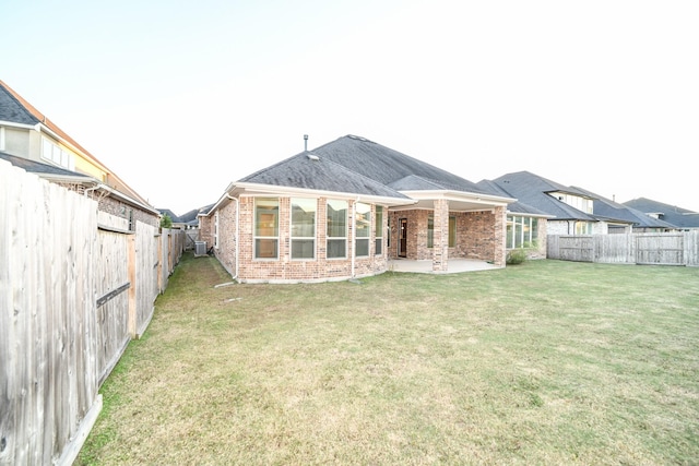 rear view of property with a yard and a patio