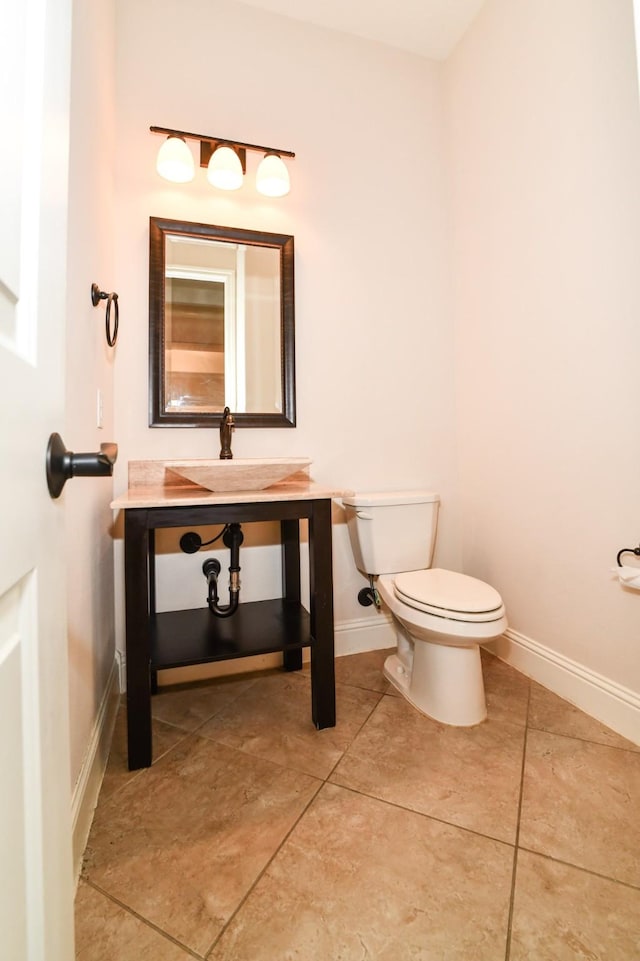 bathroom with tile patterned flooring, toilet, and sink