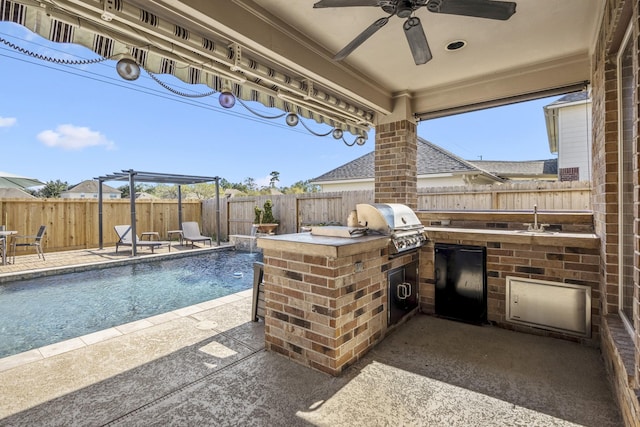 view of patio featuring a fenced in pool, an outdoor kitchen, exterior bar, pool water feature, and area for grilling