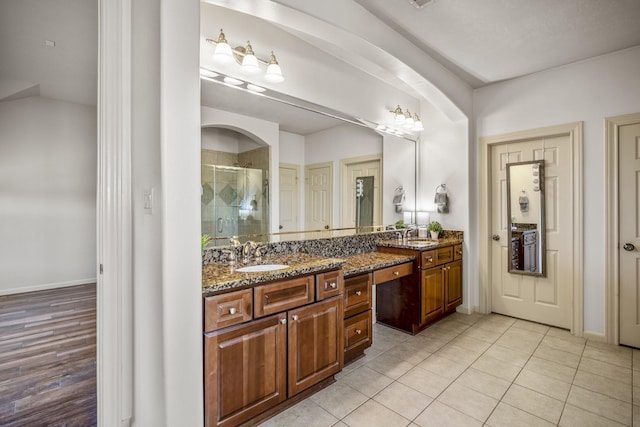 bathroom with tile patterned flooring, vanity, and walk in shower