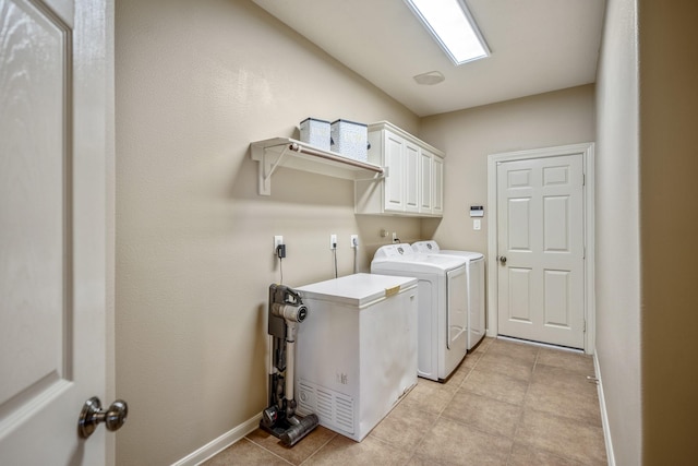 clothes washing area with cabinets and separate washer and dryer