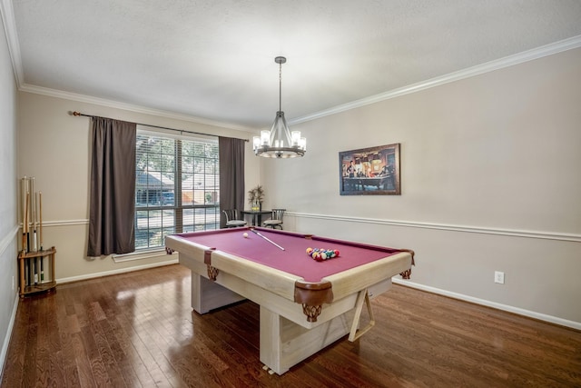 game room with a notable chandelier, dark hardwood / wood-style flooring, ornamental molding, and billiards