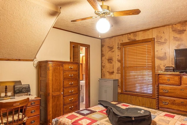 bedroom with ceiling fan, wood walls, ornamental molding, and a textured ceiling