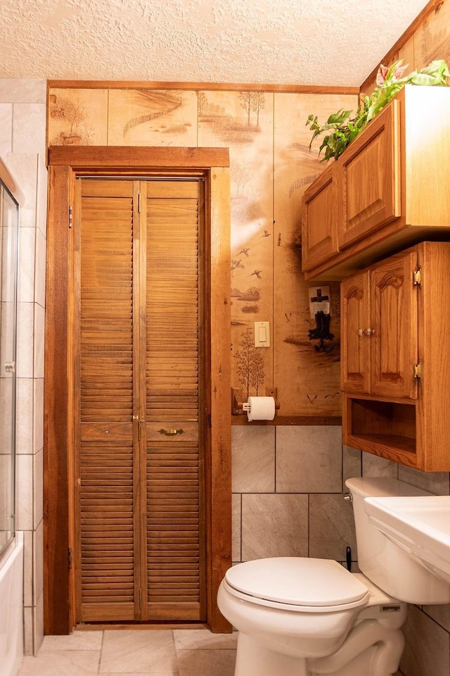 bathroom featuring tile patterned floors, a textured ceiling, and toilet