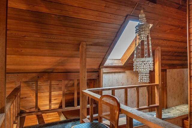 bonus room with lofted ceiling with skylight, a notable chandelier, and wood ceiling