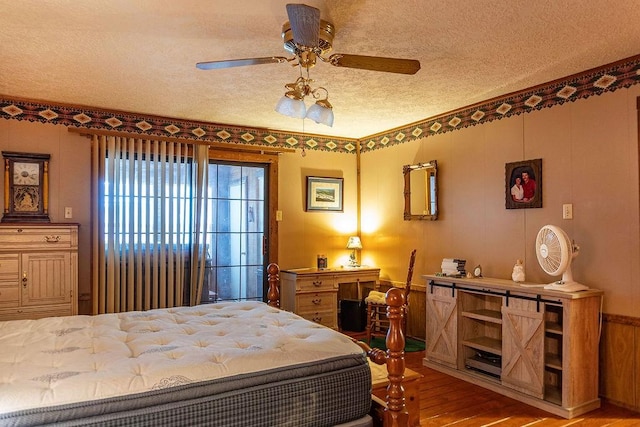 bedroom featuring ceiling fan, light hardwood / wood-style flooring, and a textured ceiling