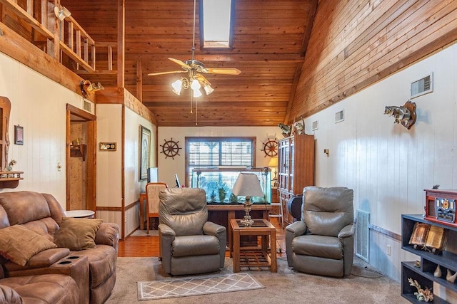 carpeted living room featuring high vaulted ceiling, ceiling fan, wooden walls, and wood ceiling