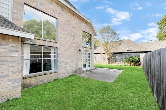 back of property featuring french doors, a patio, and a lawn