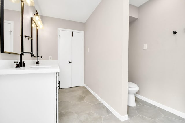 bathroom with tile patterned flooring, vanity, and toilet