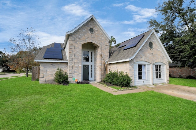 french country home with a front yard and solar panels