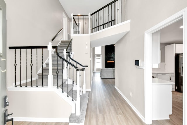 stairway featuring a large fireplace and wood-type flooring