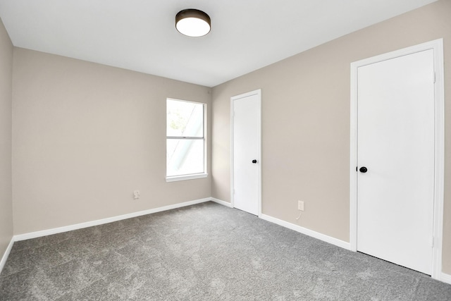 spare room with dark carpet