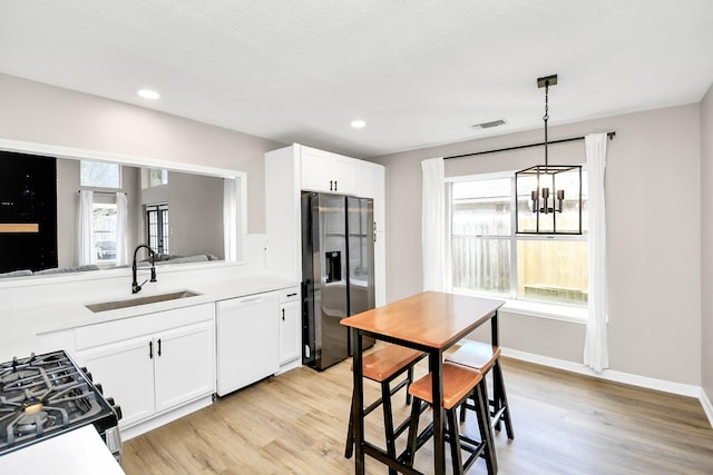 kitchen featuring stainless steel fridge, dishwasher, plenty of natural light, and sink