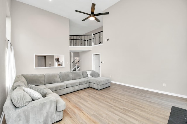 living room with ceiling fan, light hardwood / wood-style flooring, and high vaulted ceiling