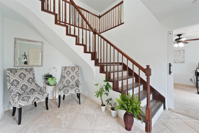 stairway featuring ceiling fan and carpet floors