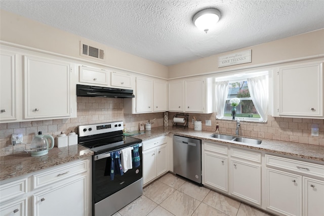 kitchen featuring appliances with stainless steel finishes, backsplash, a textured ceiling, sink, and white cabinets