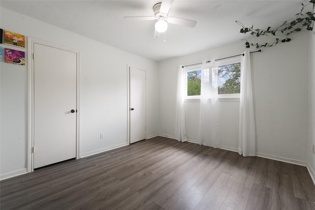 unfurnished bedroom featuring ceiling fan, dark hardwood / wood-style flooring, and a textured ceiling