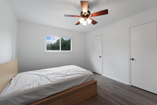 bedroom with dark hardwood / wood-style flooring and ceiling fan