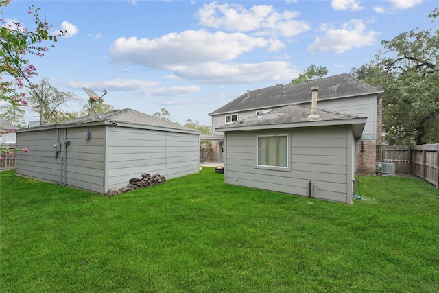 rear view of house with a yard, central AC unit, and an outdoor structure