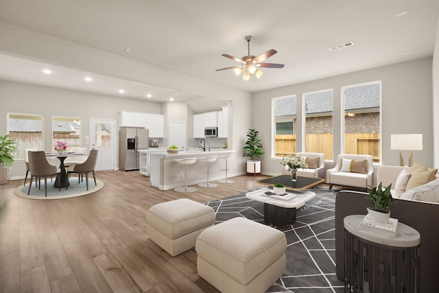 living room featuring a wealth of natural light, dark hardwood / wood-style flooring, ceiling fan, and sink