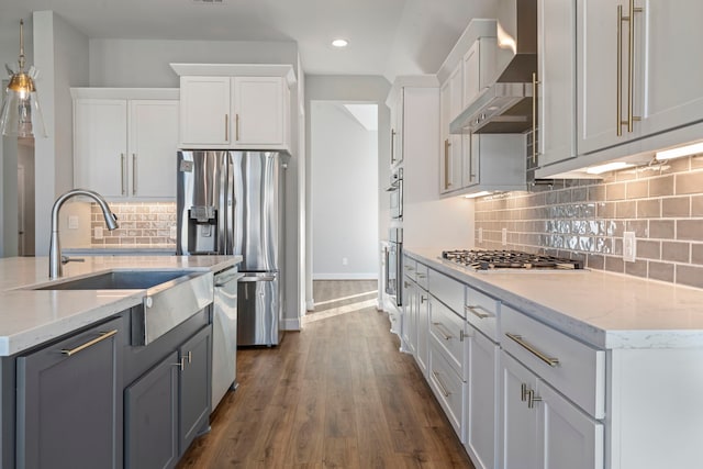 kitchen featuring decorative backsplash, appliances with stainless steel finishes, dark hardwood / wood-style flooring, wall chimney exhaust hood, and white cabinets