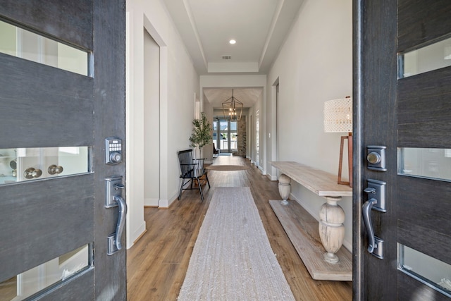 foyer featuring hardwood / wood-style floors and a chandelier