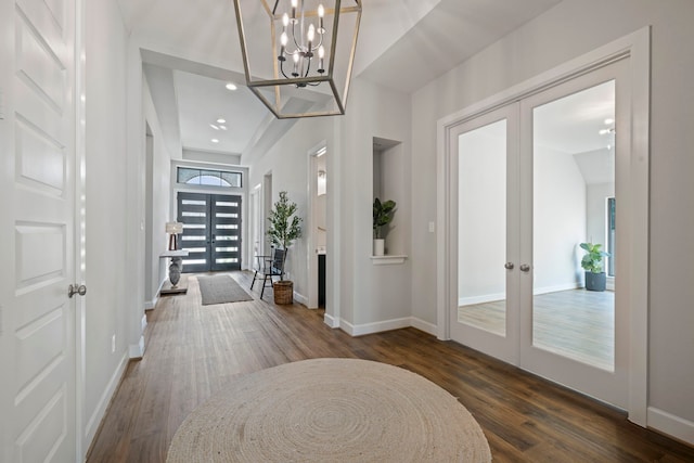 entryway featuring dark hardwood / wood-style floors, a chandelier, and french doors