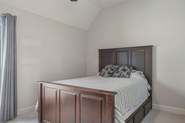 bedroom featuring light carpet and lofted ceiling