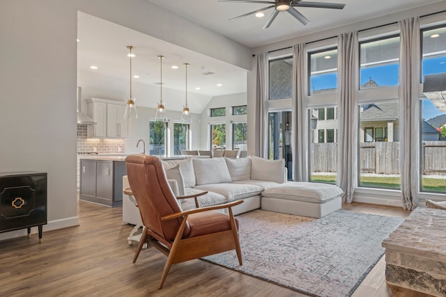 living room featuring light wood-type flooring, ceiling fan, and lofted ceiling