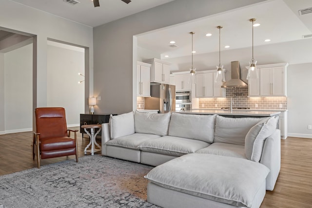 living room featuring ceiling fan and light hardwood / wood-style floors