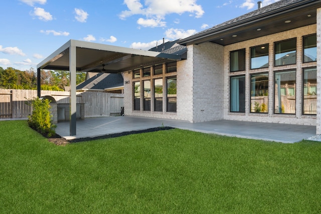 rear view of house featuring a yard and a patio