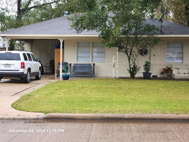 ranch-style home featuring a front yard and a carport