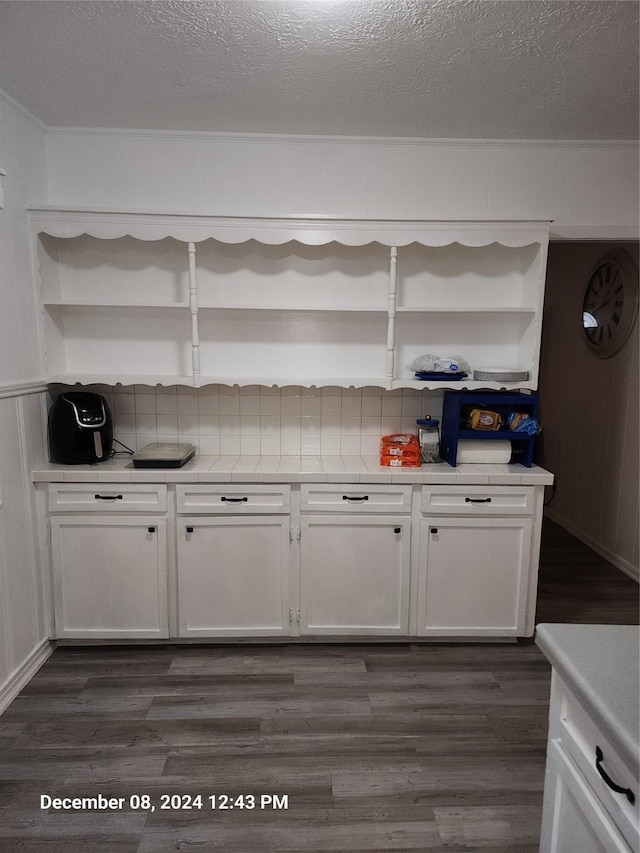 kitchen with a textured ceiling, dark hardwood / wood-style flooring, and white cabinetry